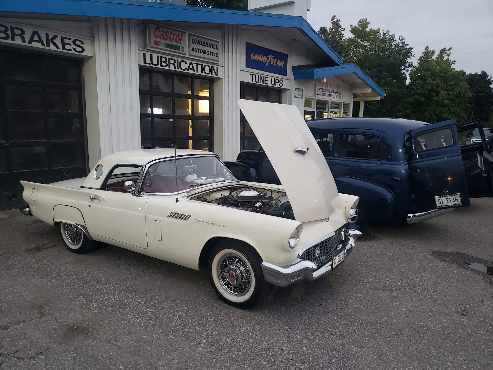 Cars parked outside Underhill Automotive's service bays at dusk.